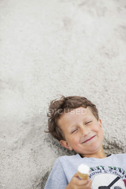 Щасливий хлопчик лежить з морозивом — стокове фото