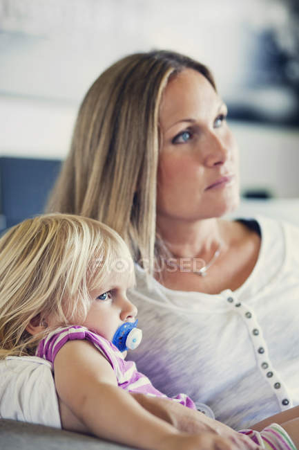 Daughter and mother sitting on sofa — Stock Photo