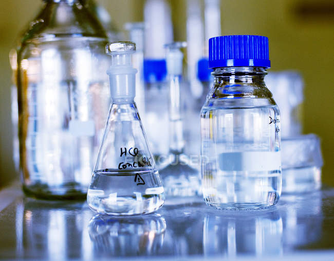 Récipients en verre sur la table au laboratoire — Photo de stock
