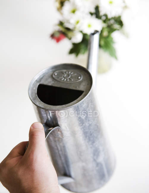 Hand holding watering can — Stock Photo