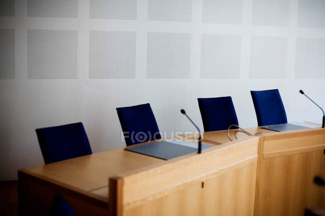 Micrófonos en mesa de conferencia vacía - foto de stock