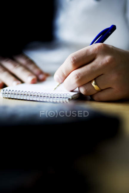 Hombre escribiendo en bloc de notas - foto de stock