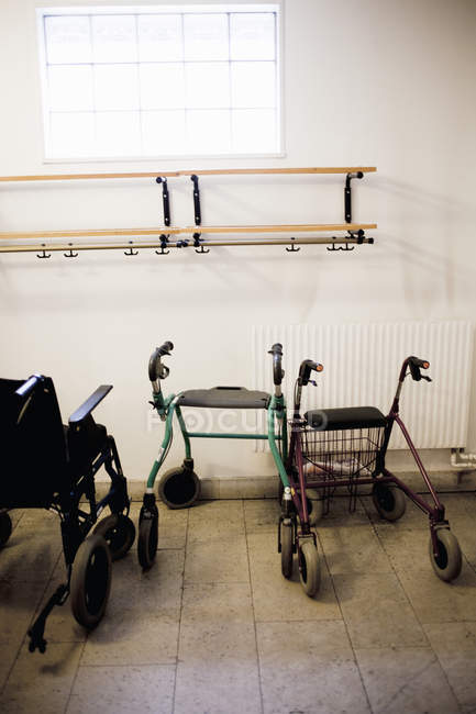 Rodillos y silla de ruedas en la habitación - foto de stock