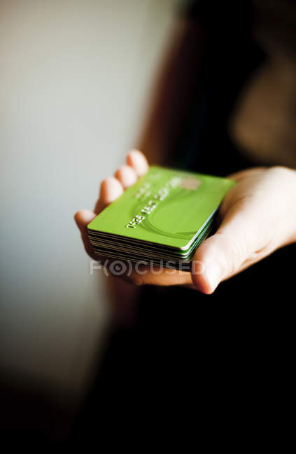 Pessoa segurando cartões de crédito empilhados — Fotografia de Stock