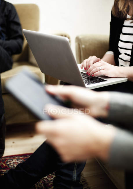 Personnes utilisant une tablette numérique et un ordinateur portable — Photo de stock