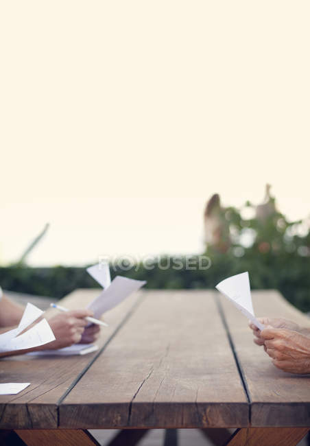 Hands holding papers at table — Stock Photo