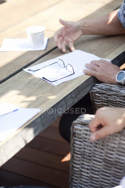 Person sitzt mit Dokumenten am Tisch — Stockfoto