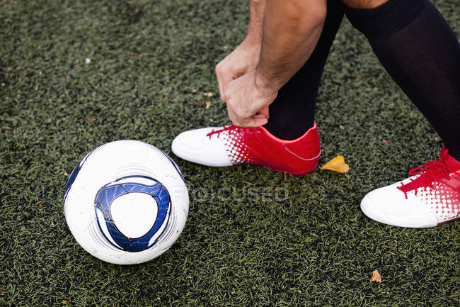 Spieler trägt Schuh auf Fußballplatz — Stockfoto