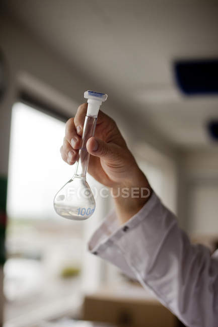 Ученый держит химическую фляжку — стоковое фото