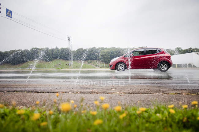 Pulvérisation d'eau sur la voiture rouge — Photo de stock