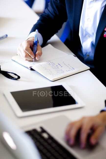 Businessman writing in diary — Stock Photo