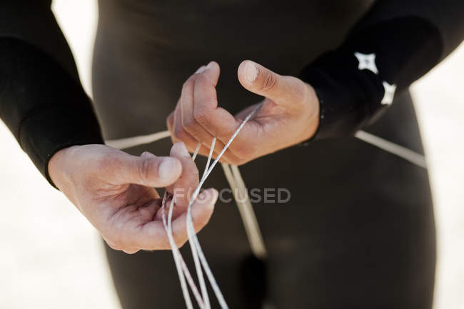 Man in wetsuit holding strings — Stock Photo