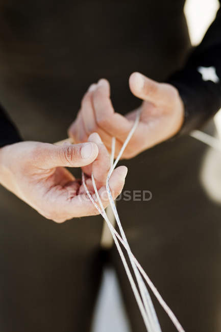 Homme en combinaison tenant des cordes — Photo de stock
