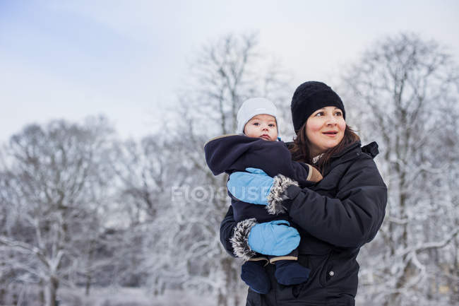 Madre llevando niño pequeño - foto de stock