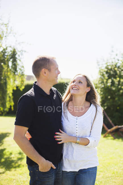 Happy couple standing in back yard — Stock Photo