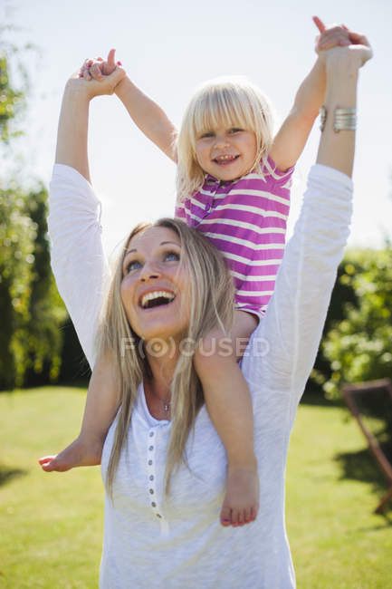 Mãe alegre carregando filha — Fotografia de Stock