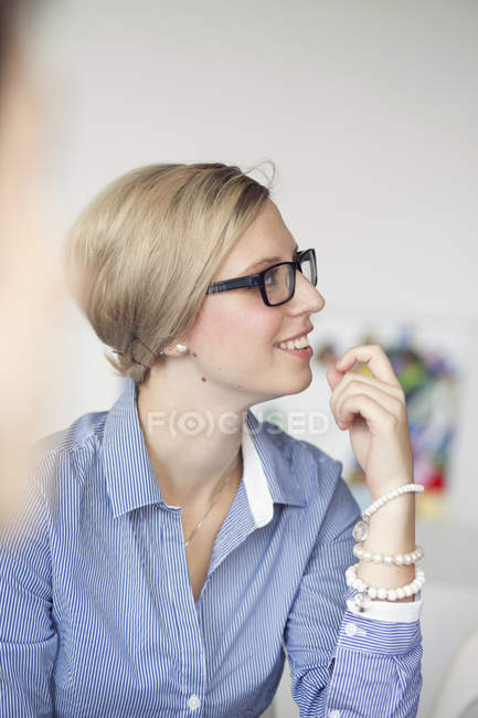 Femme d'affaires souriante détournant les yeux — Photo de stock