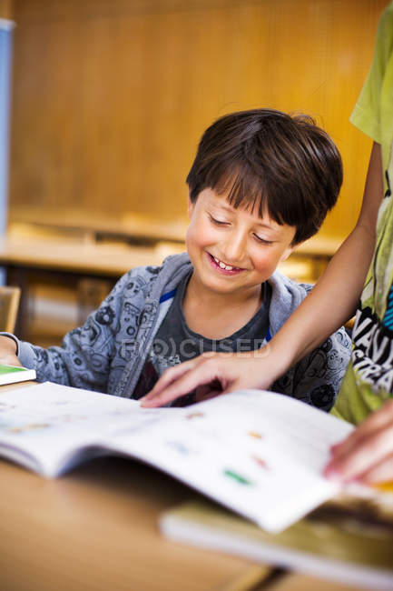 Sonriente niño leyendo libro - foto de stock