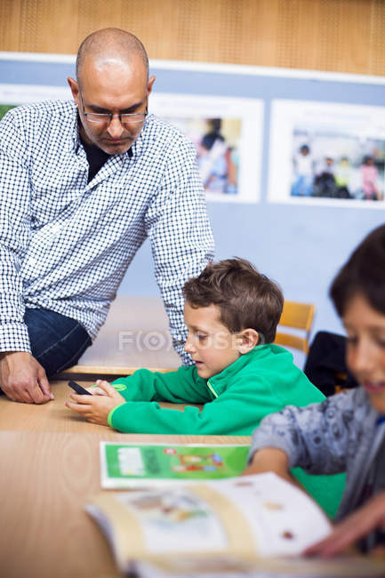 Lehrer schaut Junge an — Stockfoto