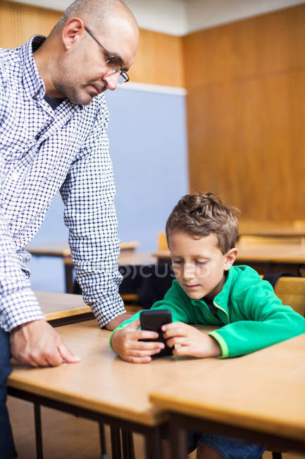 Teacher looking at schoolboy — Stock Photo