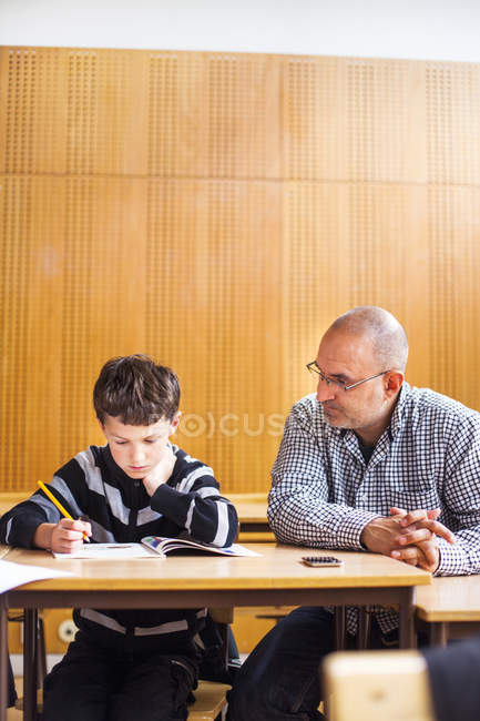 Teacher assisting boy — Stock Photo