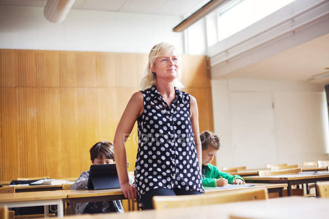 Teacher standing in front of students — Stock Photo