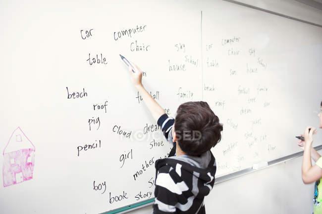 Schoolboy writing spellings — Stock Photo