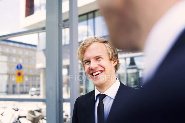 Hombre de negocios feliz mirando a colega - foto de stock