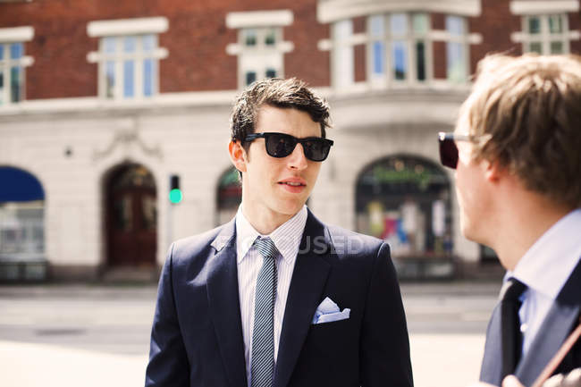 Businessmen talking while standing on street — Stock Photo