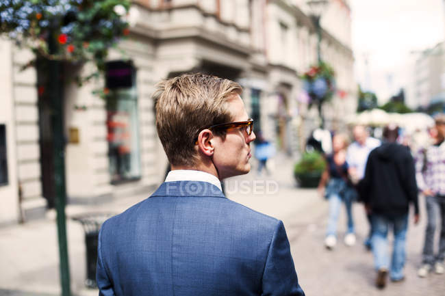Businessman walking on city street — Stock Photo