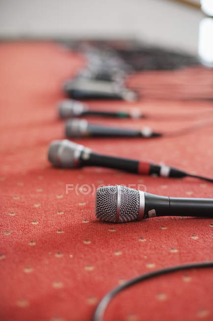 Row of microphones on red carpet — Stock Photo