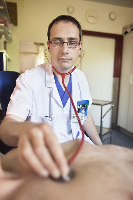 Dottore ascoltando il battito cardiaco del paziente — Foto stock