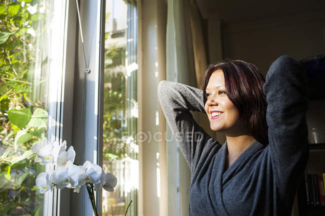 Mujer feliz por orquídeas blancas - foto de stock