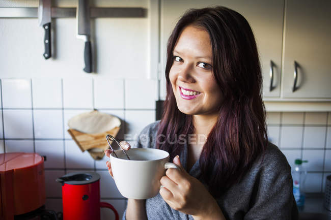 Mulher feliz segurando copo de café — Fotografia de Stock