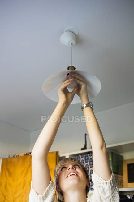 Женщина устанавливает лампочку — стоковое фото