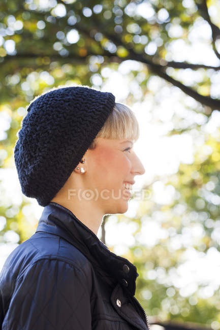 Femme heureuse portant un chapeau en tricot — Photo de stock