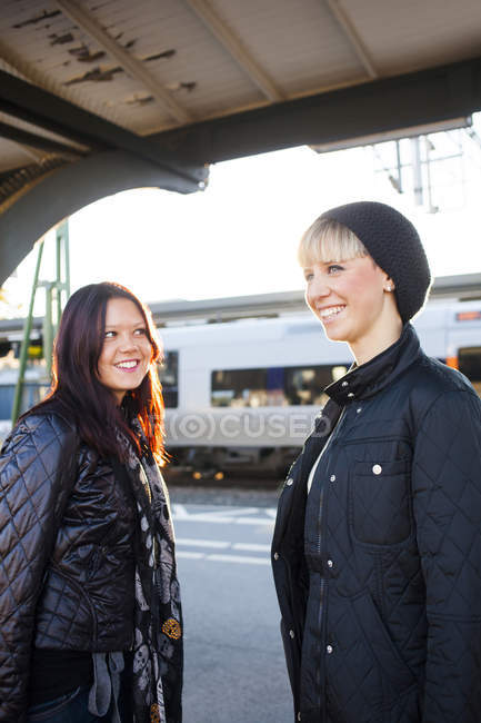 Mujeres de pie estación de ferrocarril - foto de stock