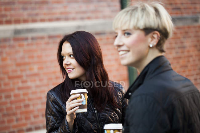 Happy women with coffee cups — Stock Photo