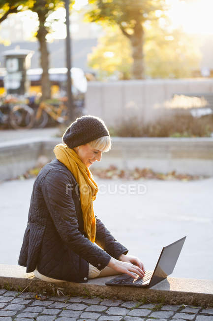 Щаслива жінка використовує ноутбук — стокове фото