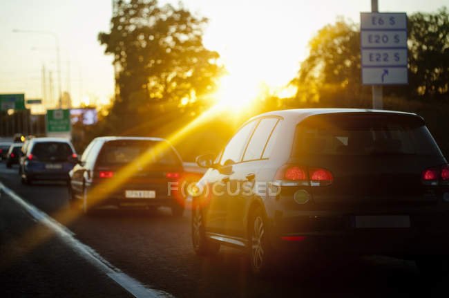 Carros na rua durante o pôr do sol — Fotografia de Stock