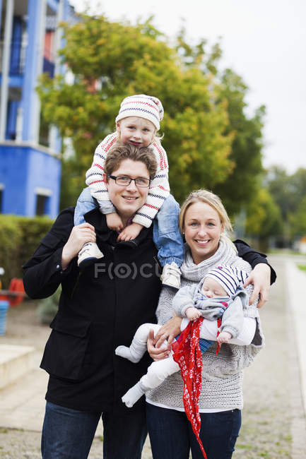 Happy family standing on footpath — Stock Photo