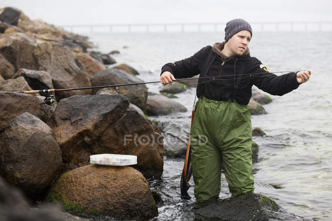 Hombre reparación de caña de pescar - foto de stock