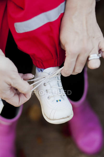 Mother tying shoelace — Stock Photo