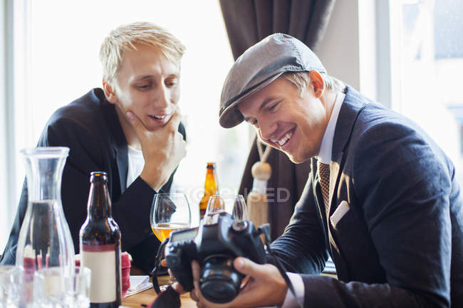 Gay hombre mostrando cámara a socio - foto de stock