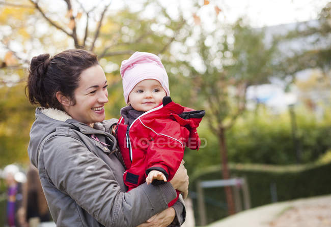 Glückliche Mutter trägt kleines Mädchen — Stockfoto