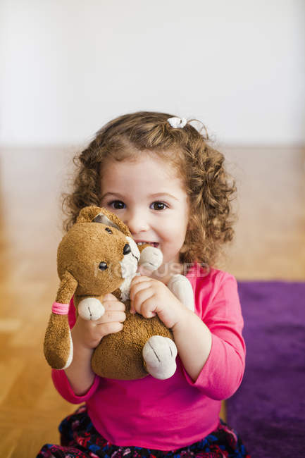 Милая девушка играет с игрушкой дома — стоковое фото