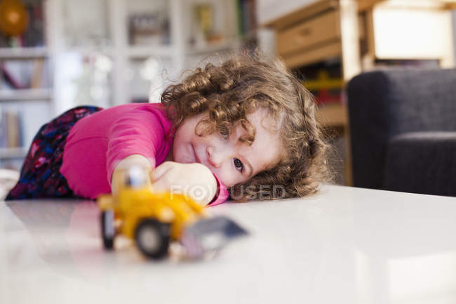 Милая девушка играет с игрушечной машиной — стоковое фото