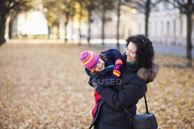 Mãe feliz carregando filha — Fotografia de Stock