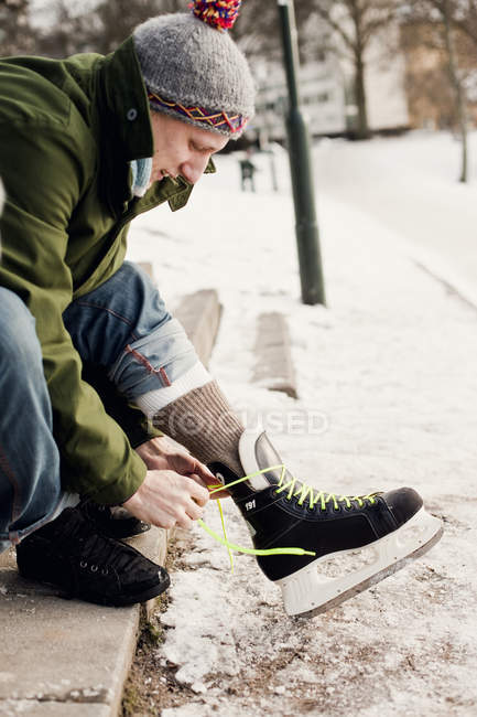 Homme attachant de la dentelle de patin à glace — Photo de stock
