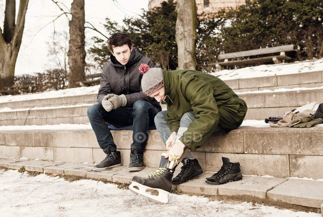 Man looking at friend tying shoelace — Stock Photo